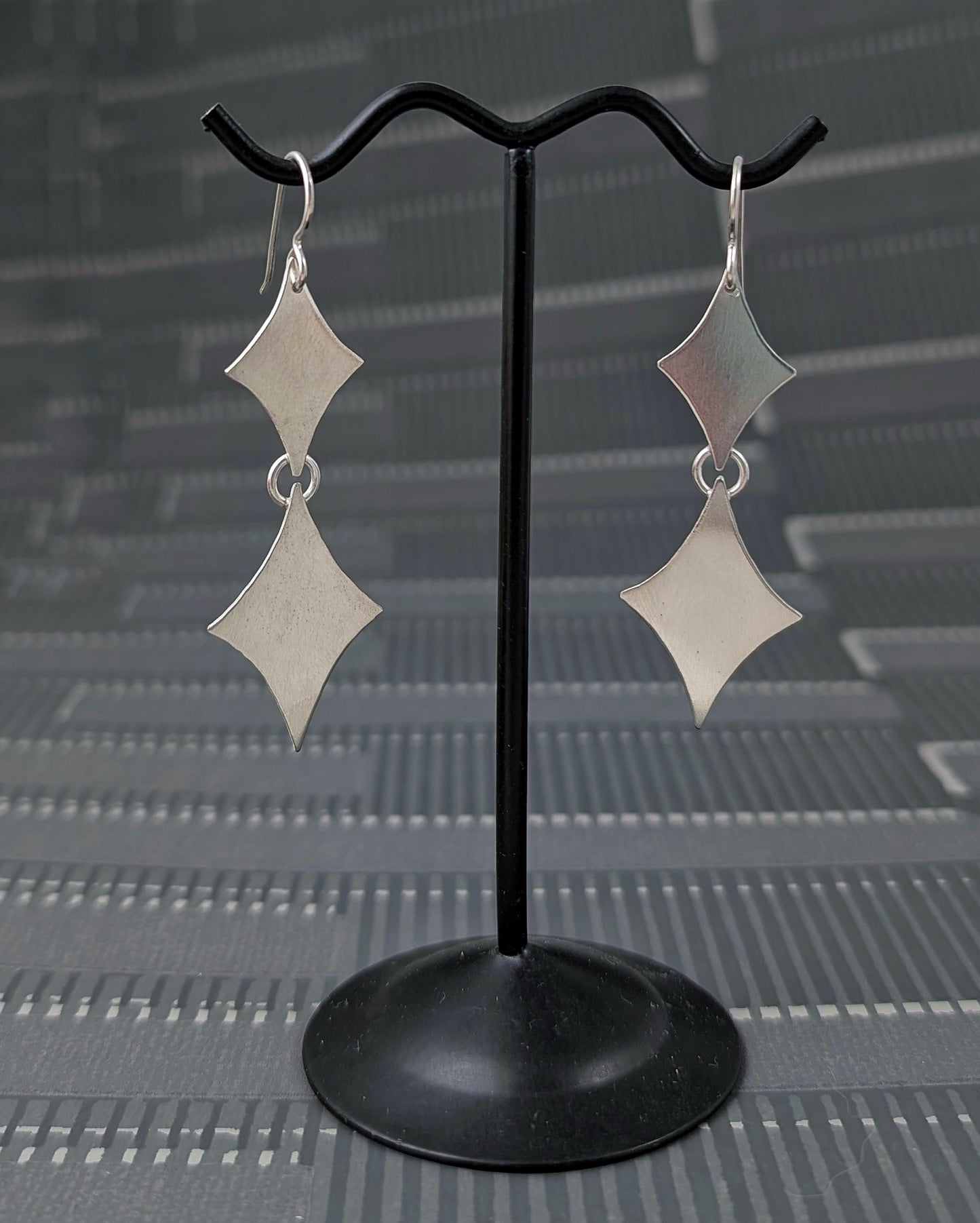 Sterling silver retro diamond earrings on an earring stand