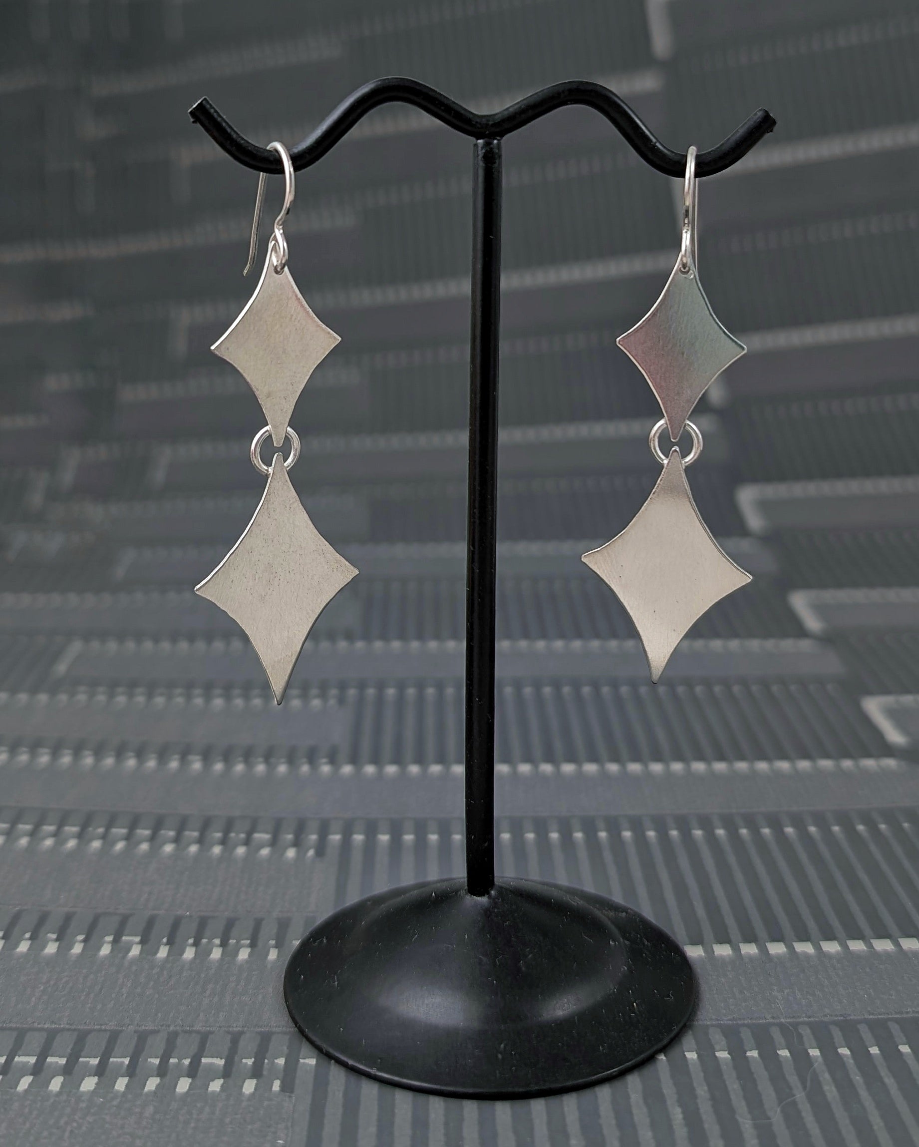 Sterling silver retro diamond earrings on an earring stand