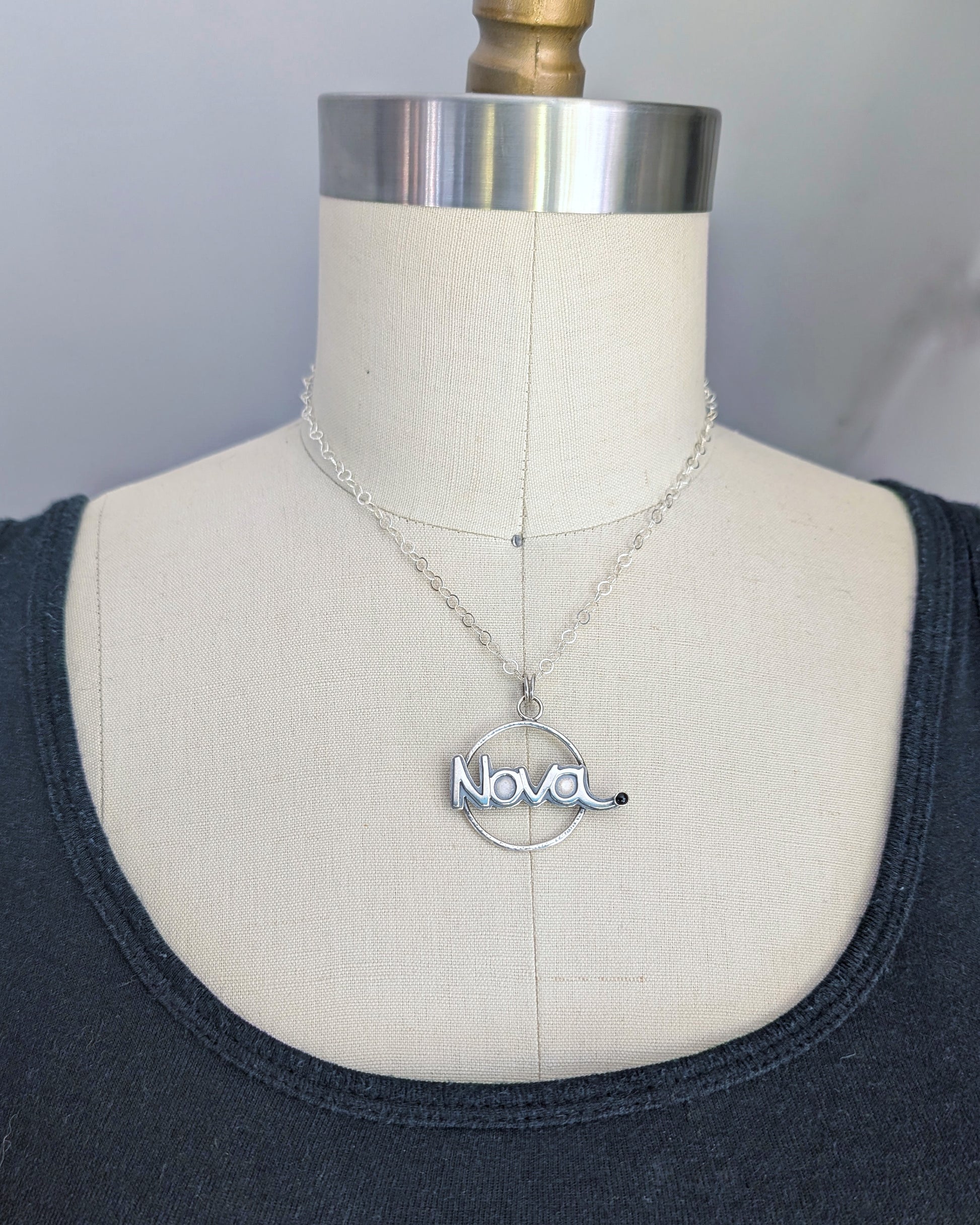 Necklace with 'Nova' pendant on a mannequin bust against a neutral background