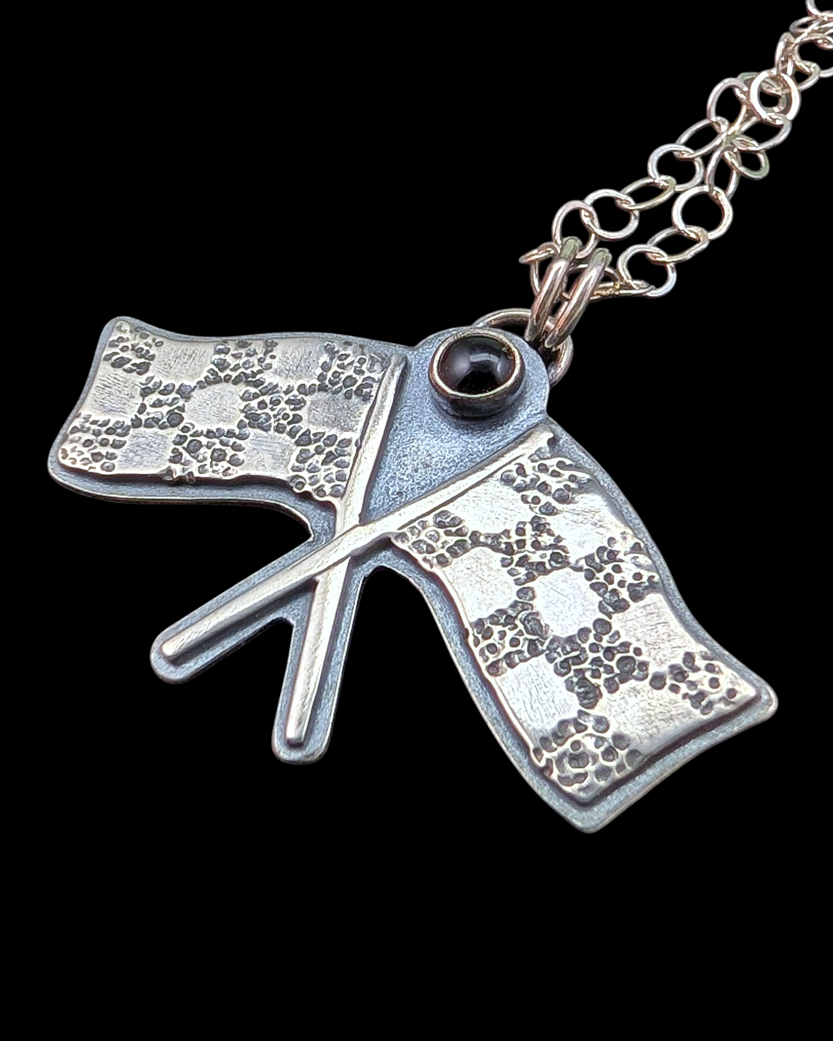 Racing flags necklace on black background