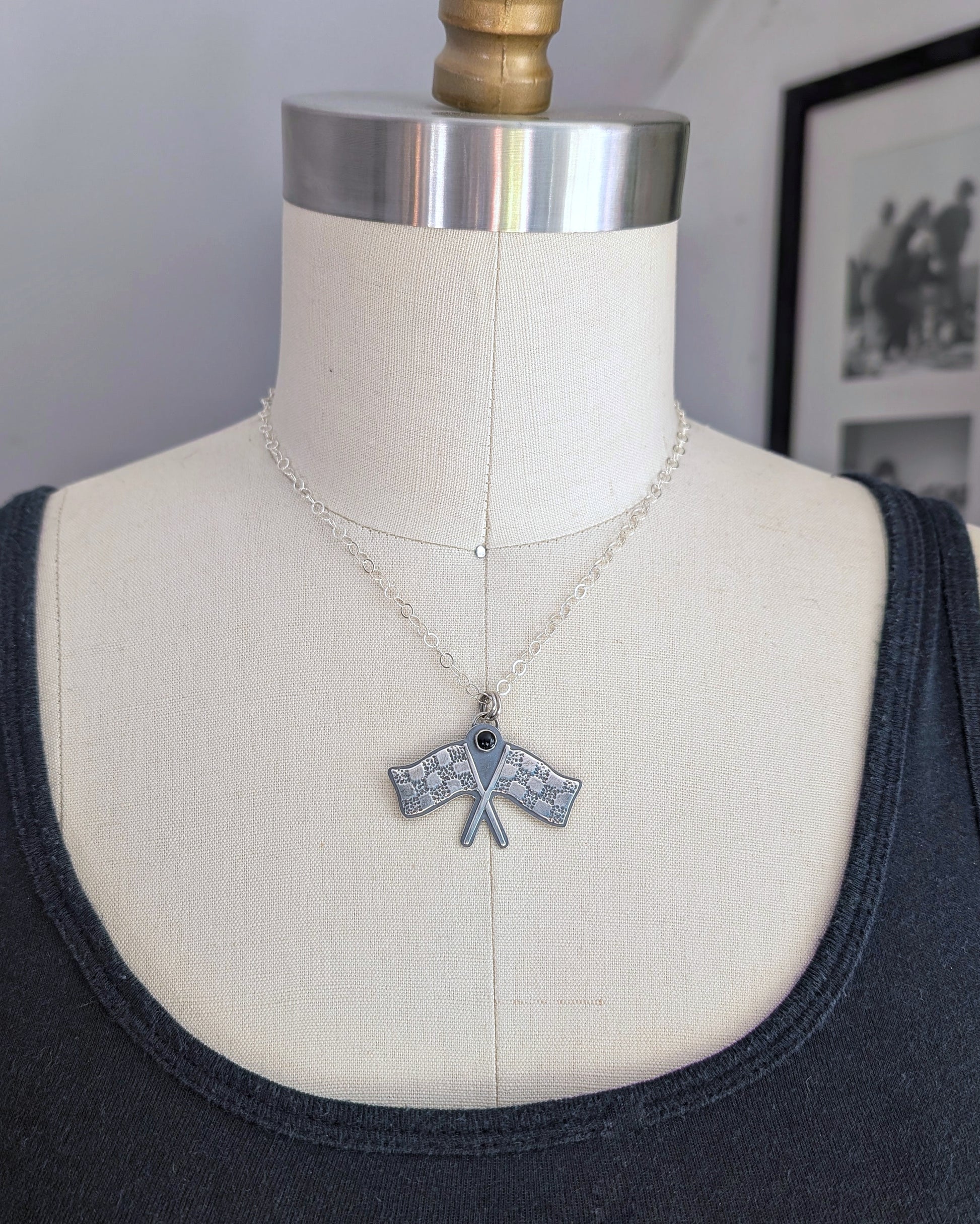 crossed Racing flags necklace on black background