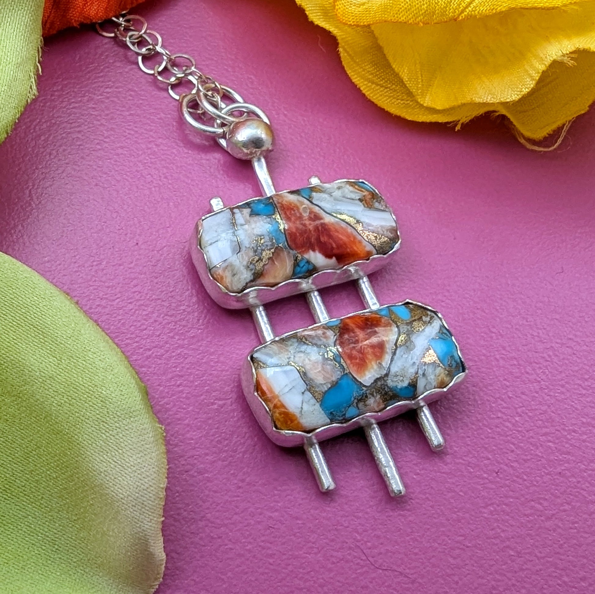 Googie inspired mid century necklace with turquoise mosaic and sterling silver on a pink background