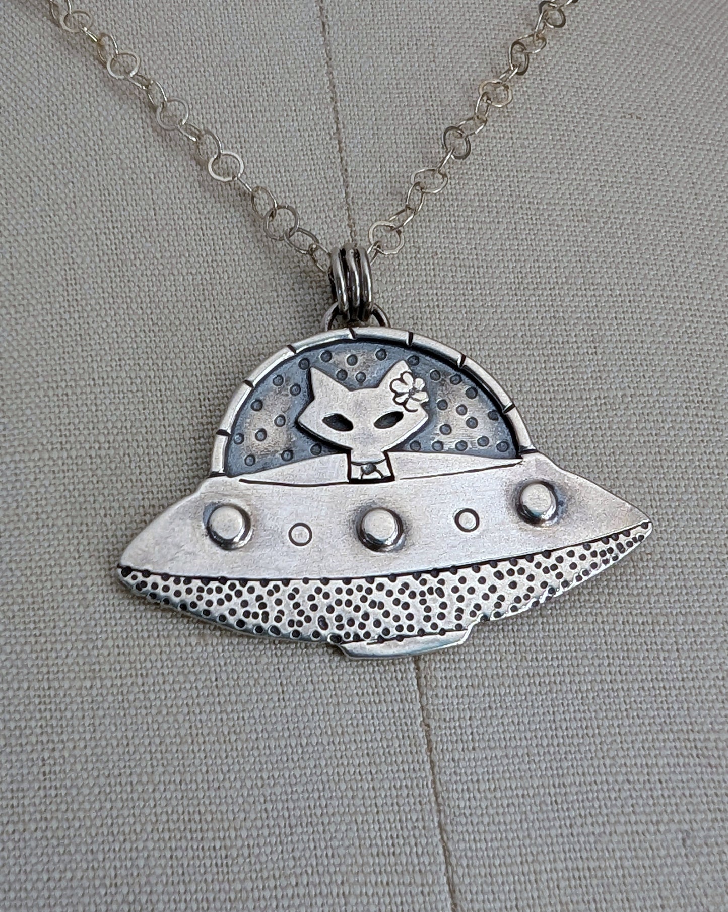 Handmade sterling silver UFO necklace with a cat sitting inside