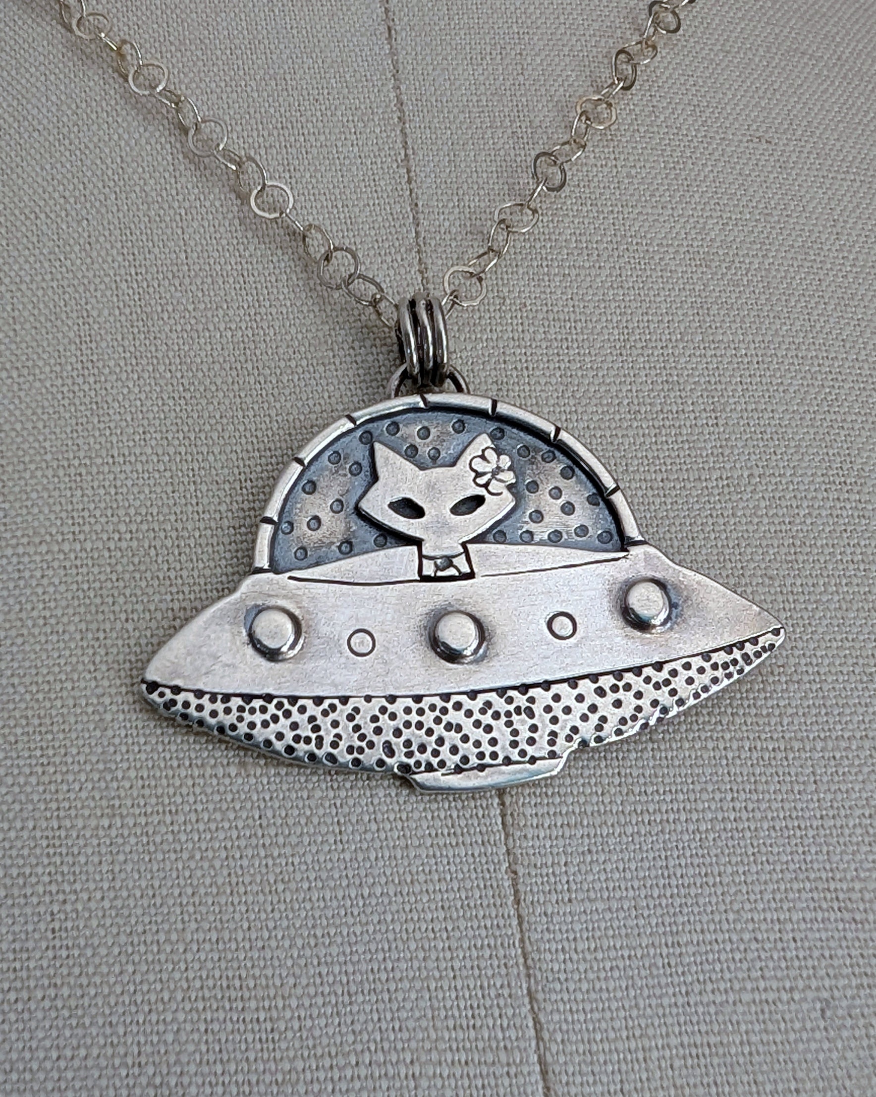 Handmade sterling silver UFO necklace with a cat sitting inside