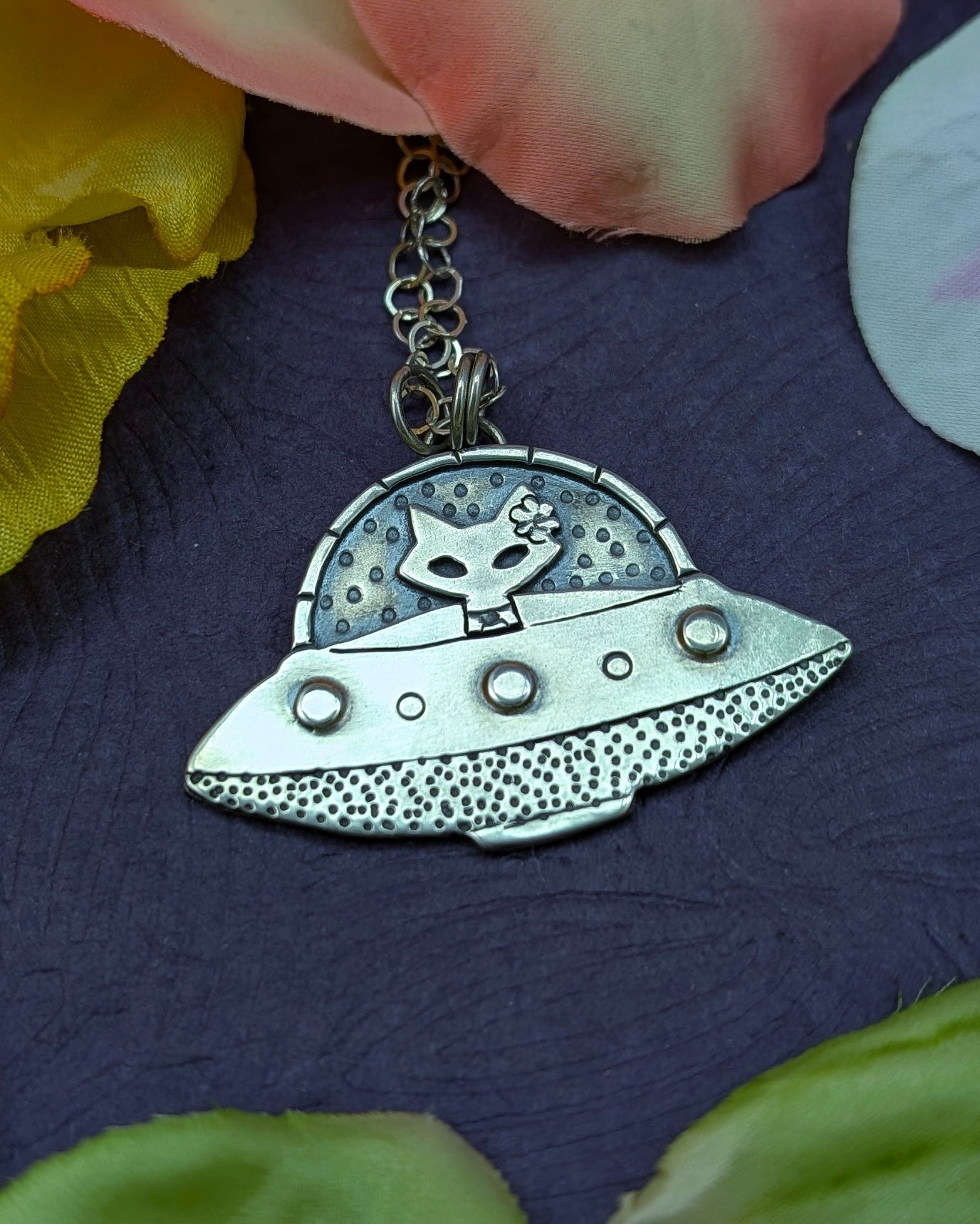 Sterling silver UFO necklace with a mid century modern cat in the driver seat on a purple background
