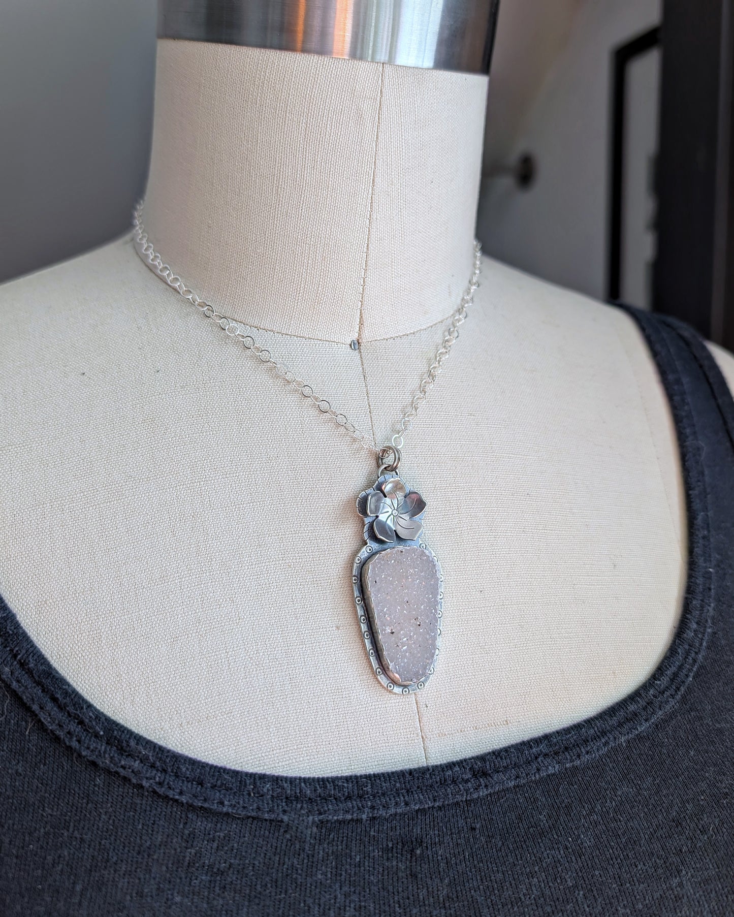 White druzy and flower necklace on a mannequin