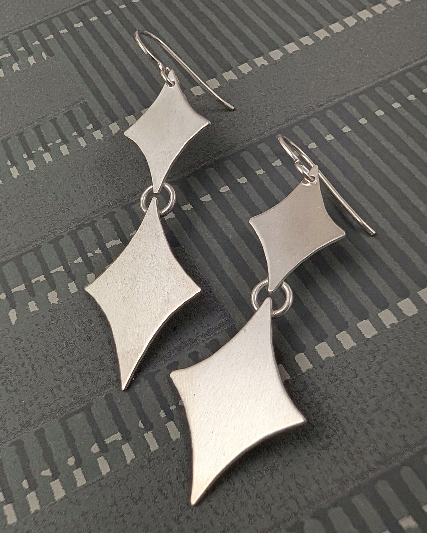 Sterling silver retro diamond earrings on a black background