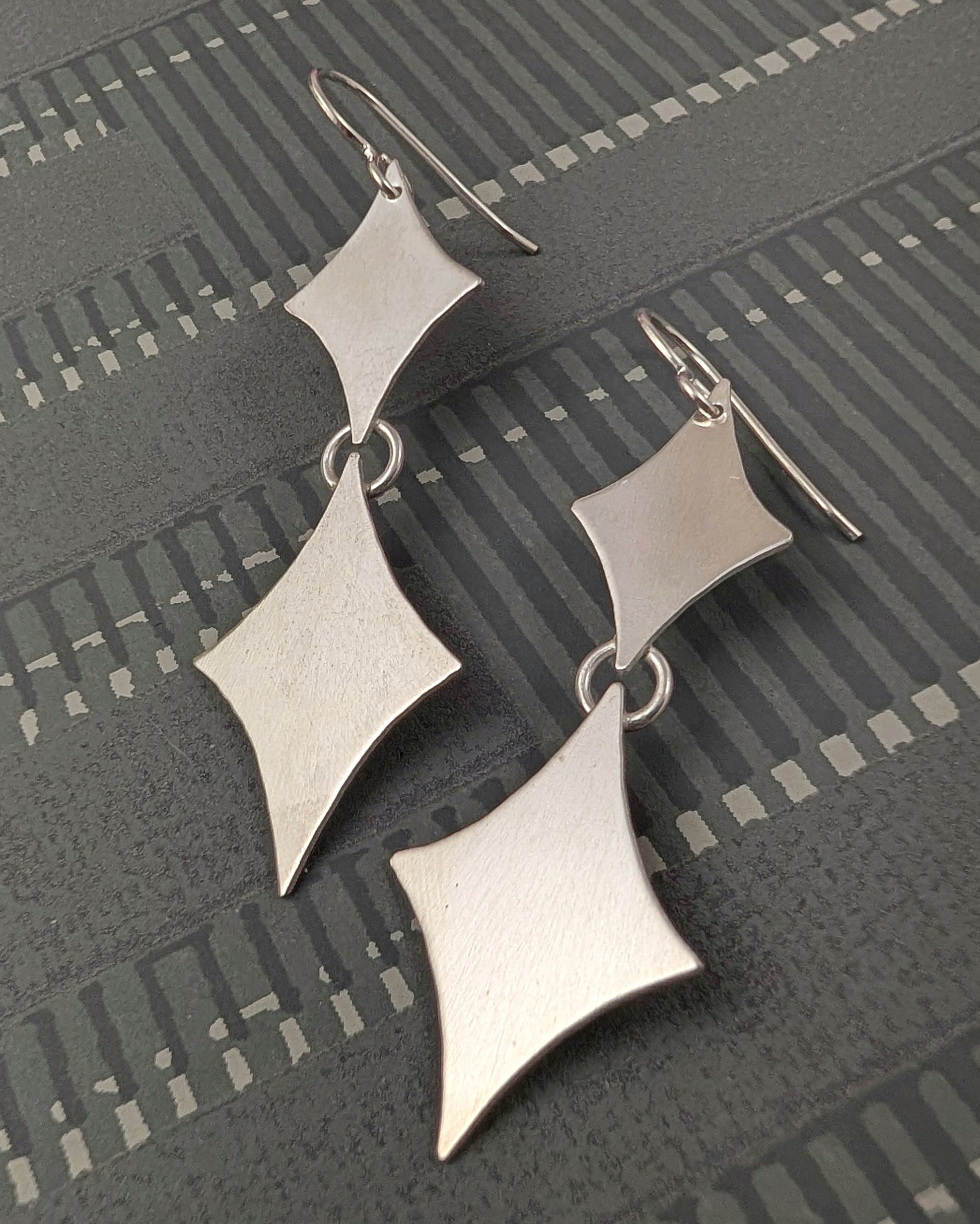 Sterling silver retro diamond earrings on a black background