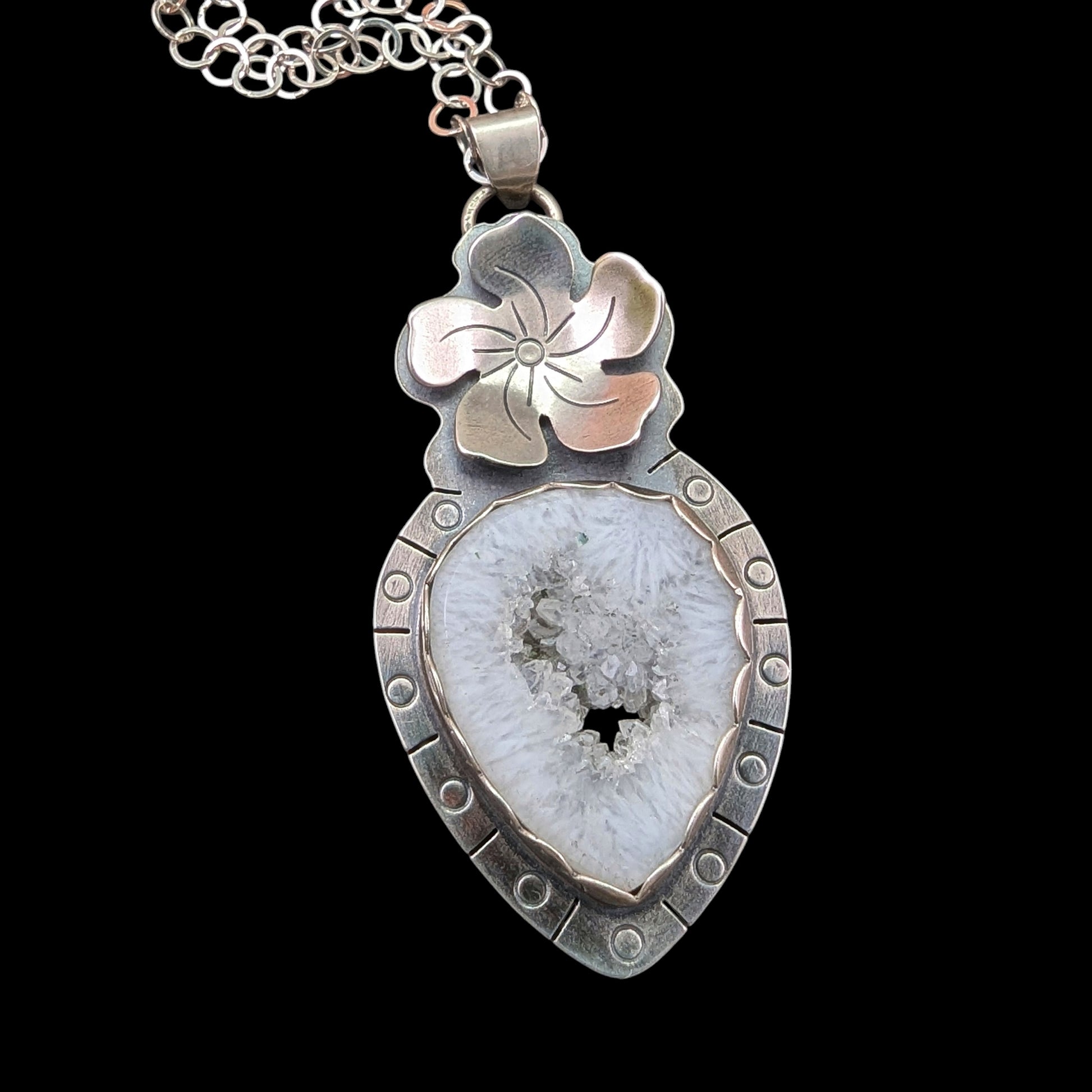 White druzy quartz stone in the center of a flower necklace in sterling silver