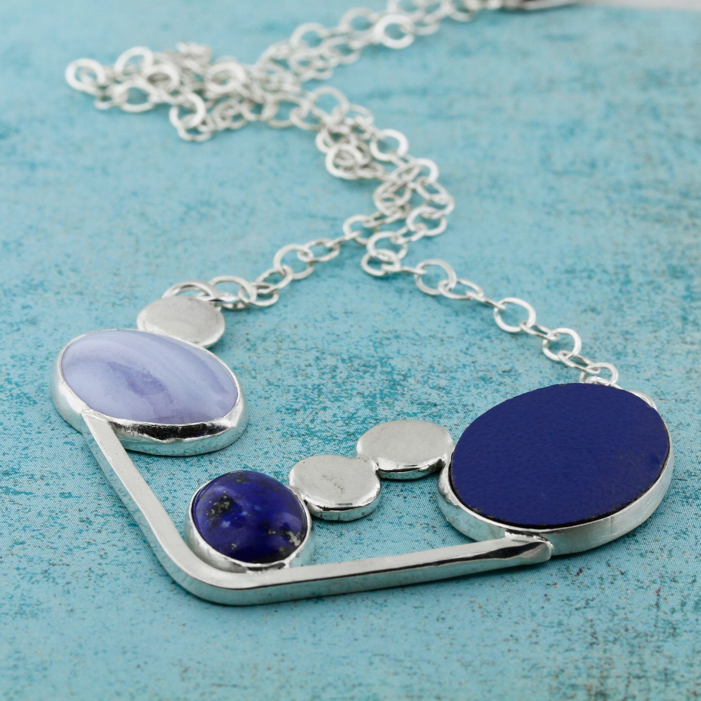 Beautiful abstract modernist necklace in blues featuring blue lace agate, lapis lazuli and laminate on wood.