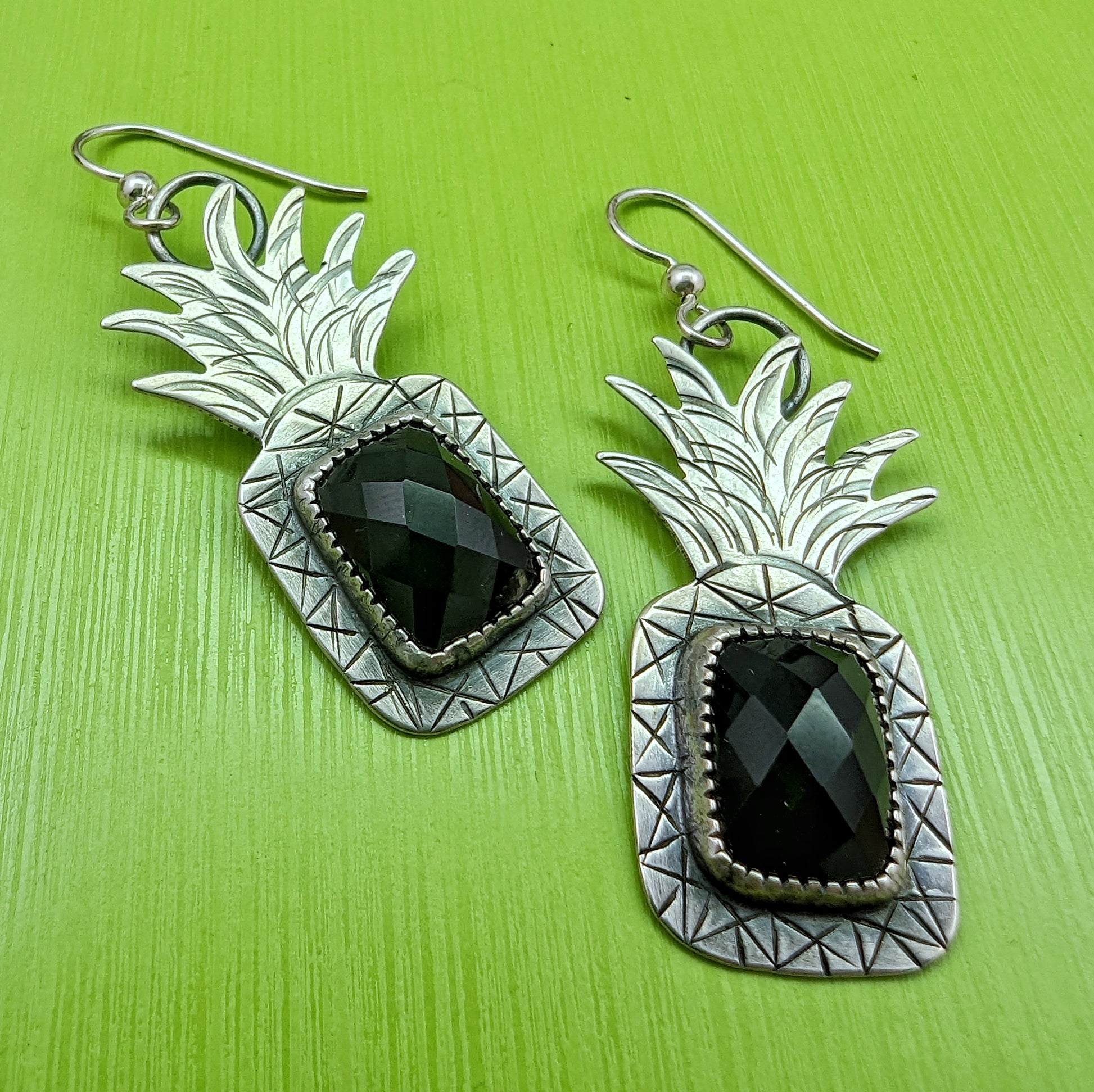 Sterling silver pineapple earrings with rectangular rosecut black onyx on green background