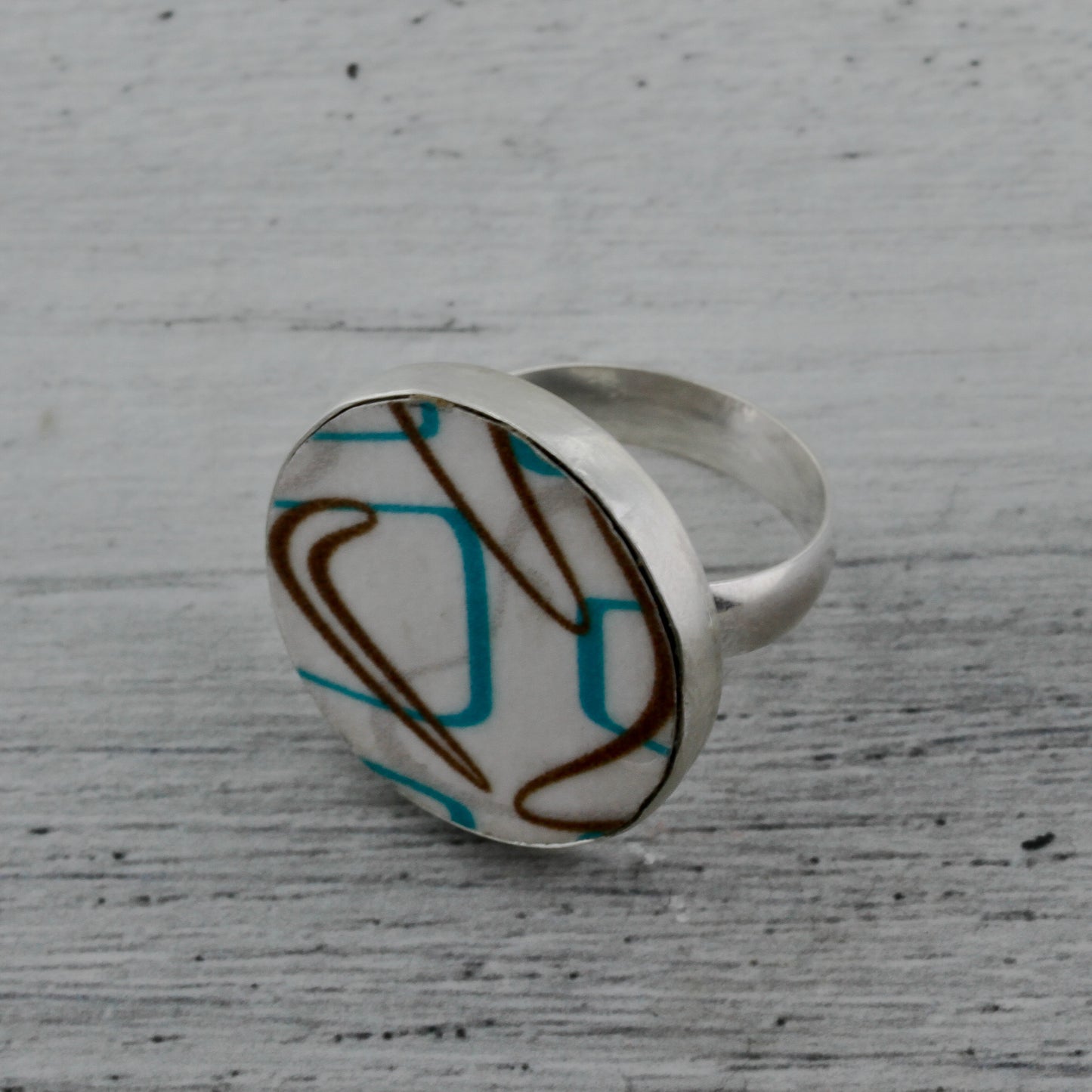 Modernist boomerang laminate on wood ring in turquoise and brown