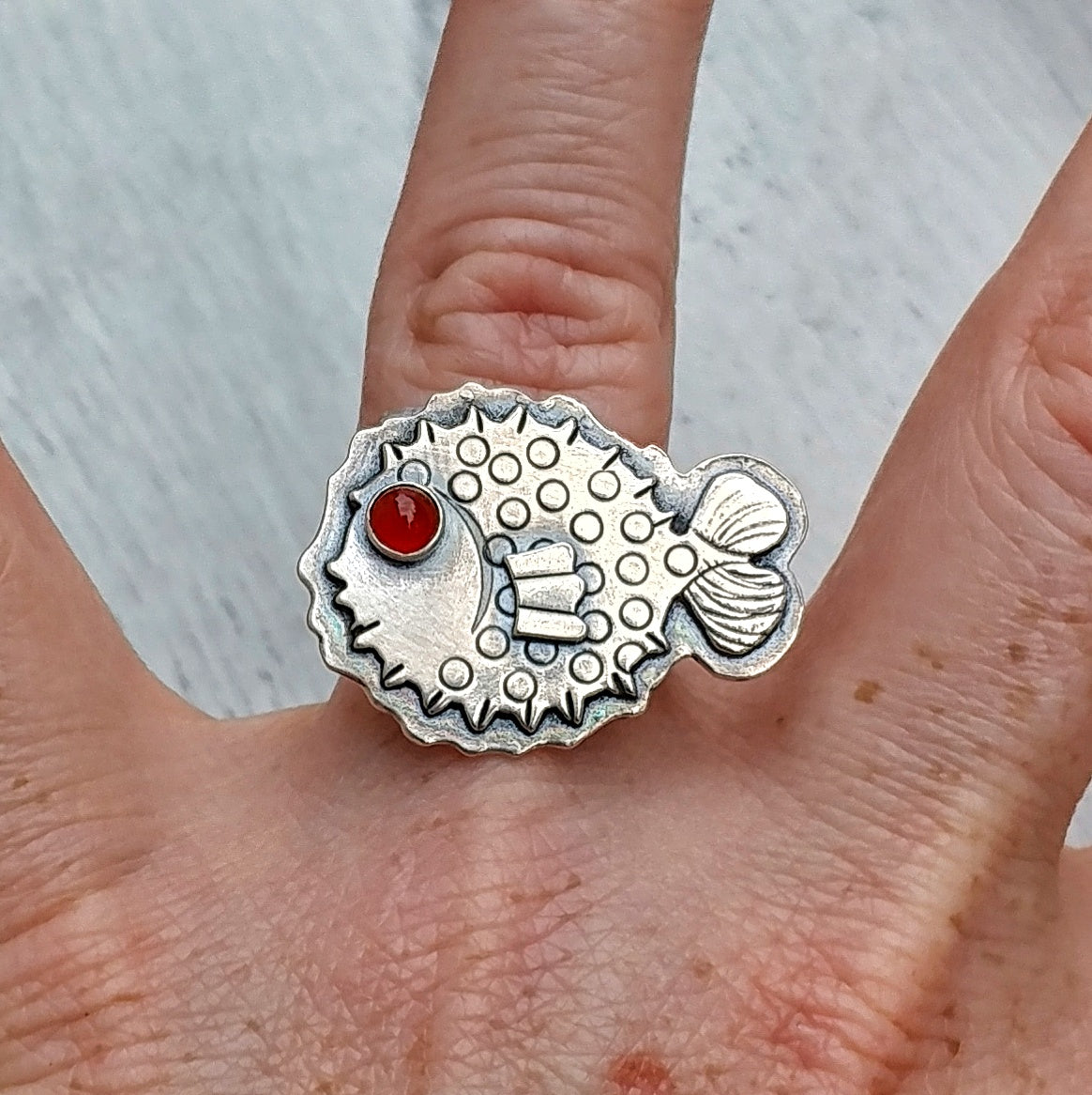 Puffer fish ring on finger with carnelian eye