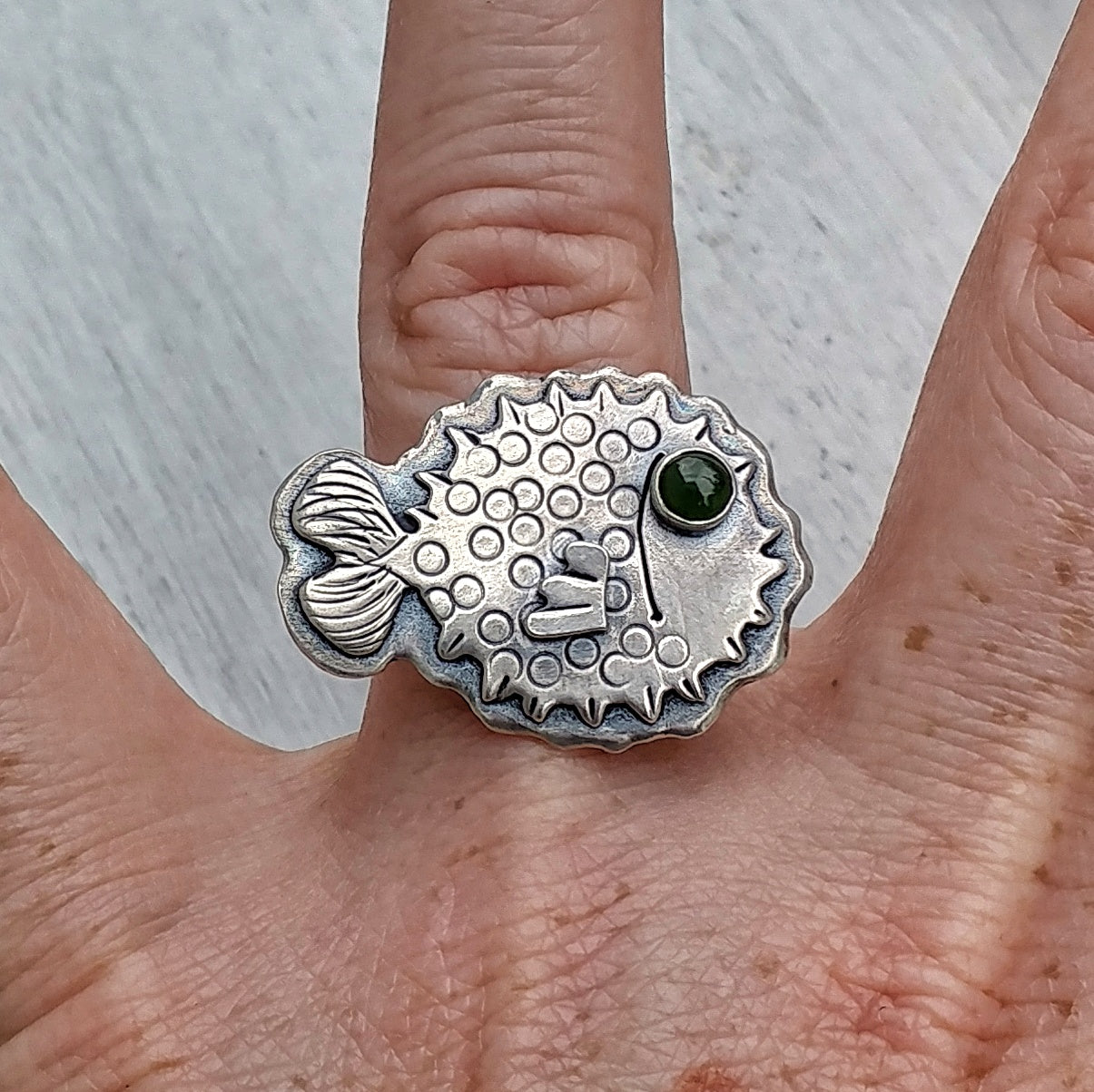 Sterling silver puffer fish ring shown on ring finger