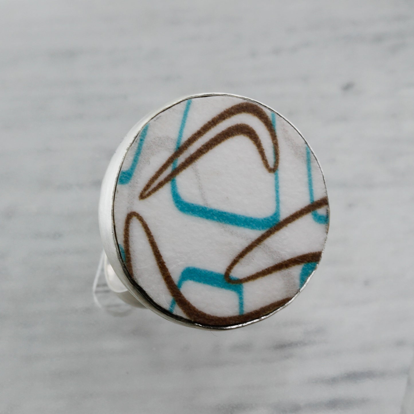 Close up of turquoise and brown boomerang laminate ring sterling silver