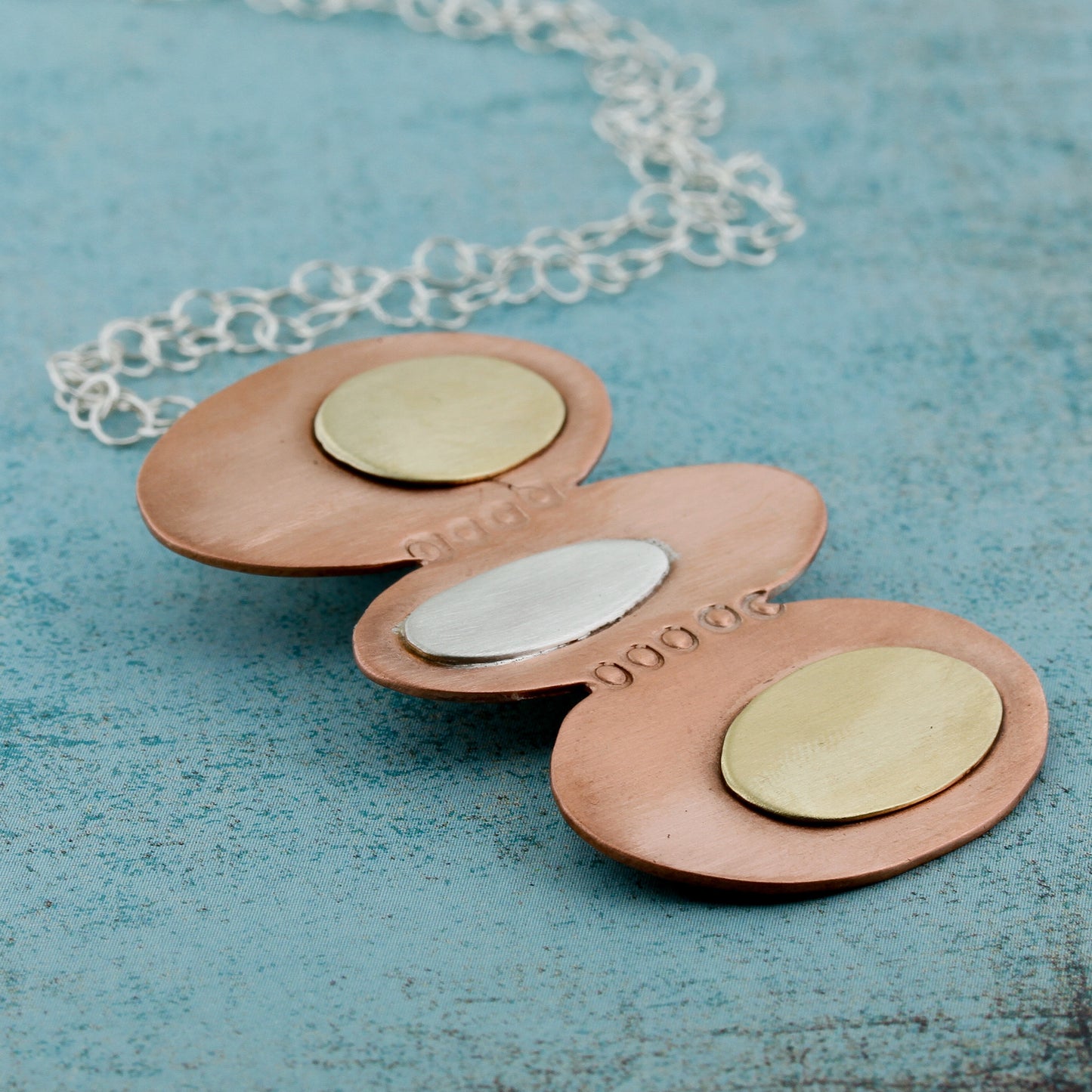 Modernist inspired ovals in copper, brass, and silver.