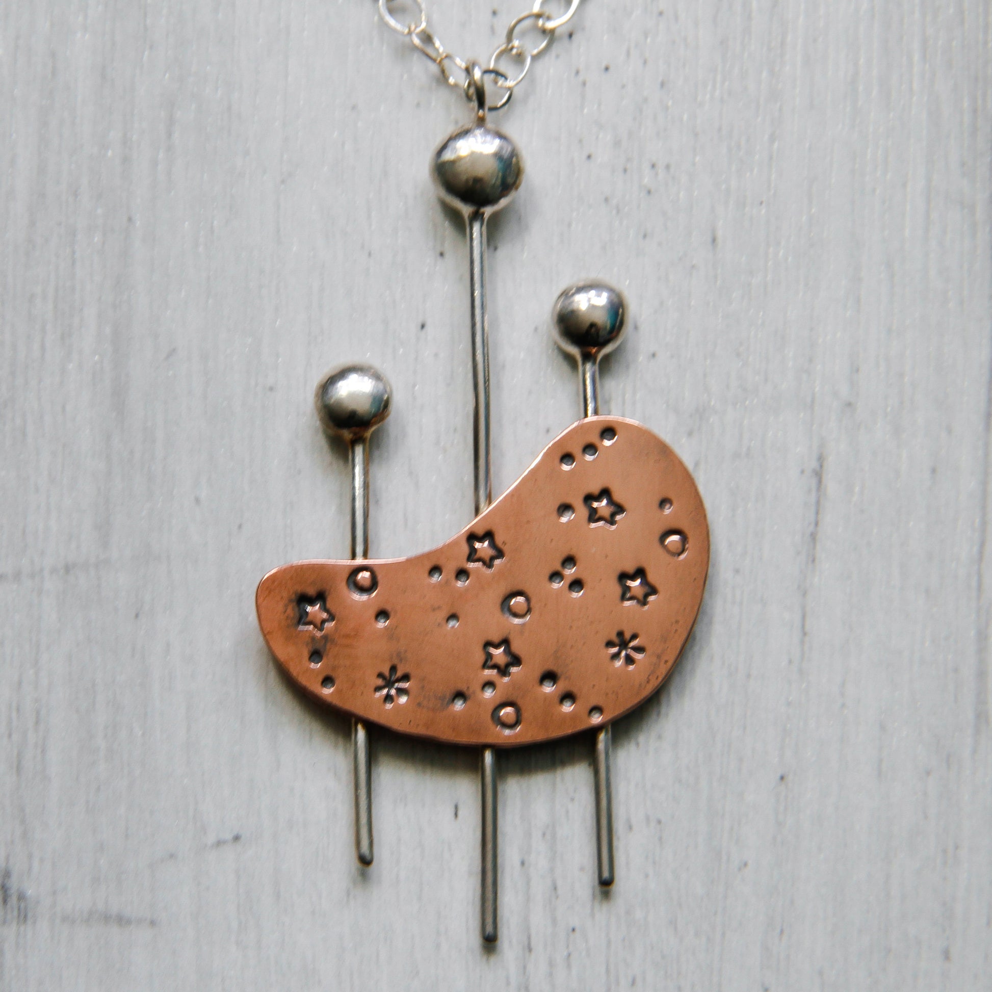 Kidney shaped copper and sterling silver necklace inspired by mid century modern design