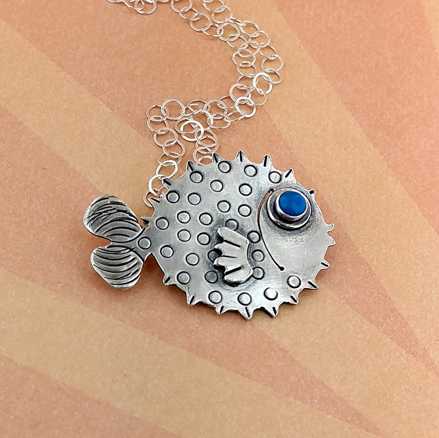 Puffer fish with gemstone eye made of sterling silver.
