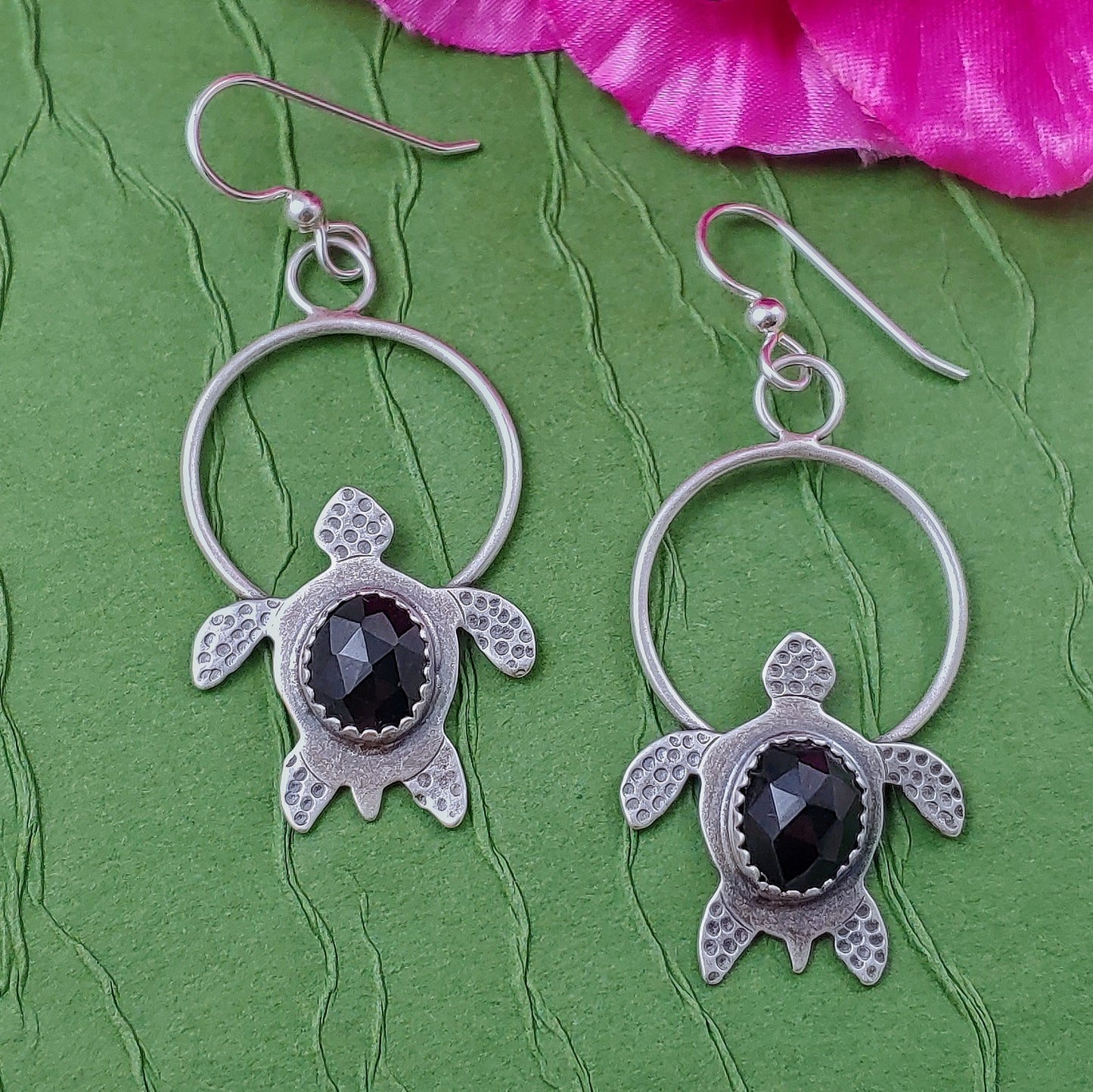 Sterling silver handmade earrings with rosecut black onyx on green background
