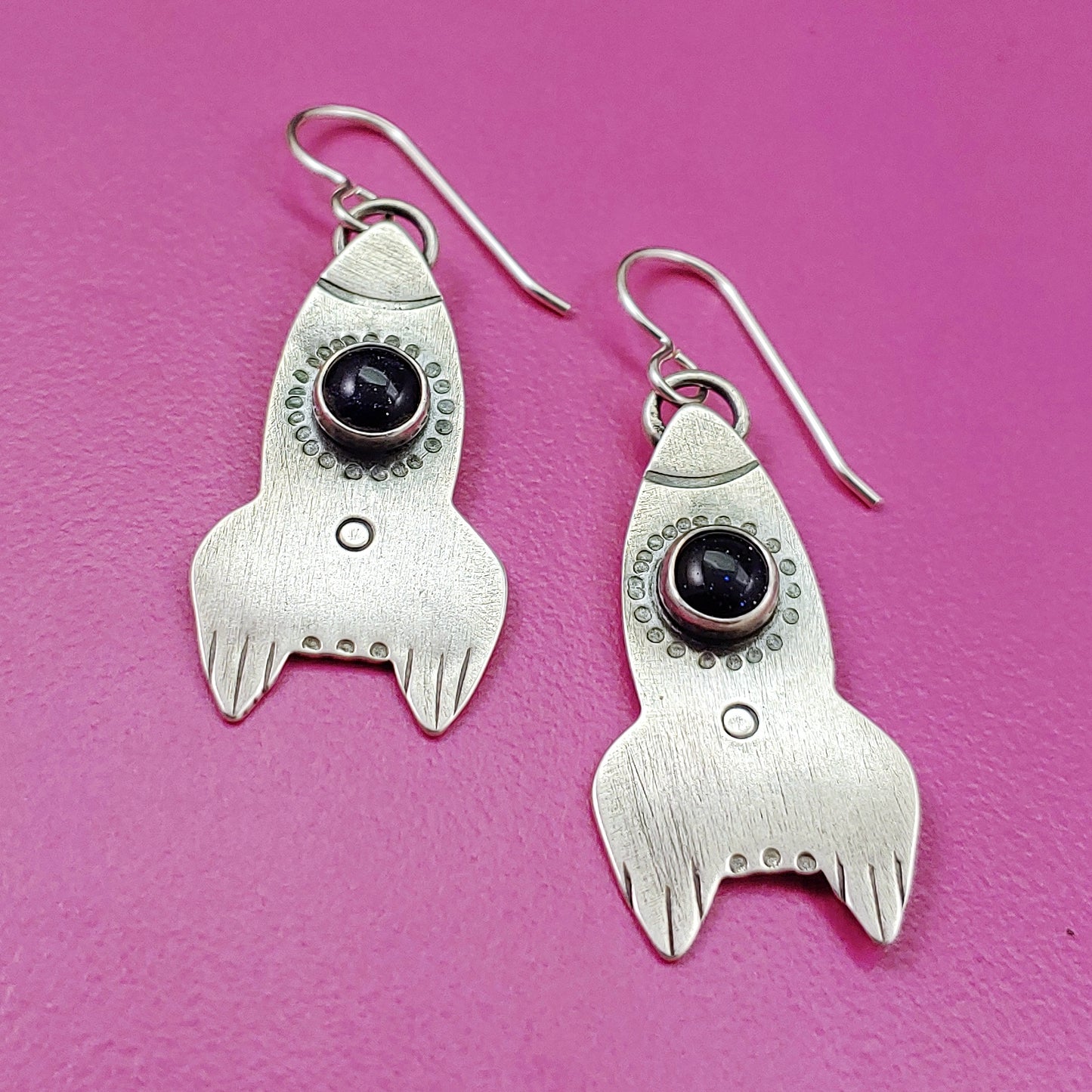 Rocket ship earrings in sterling silver on pink bacground