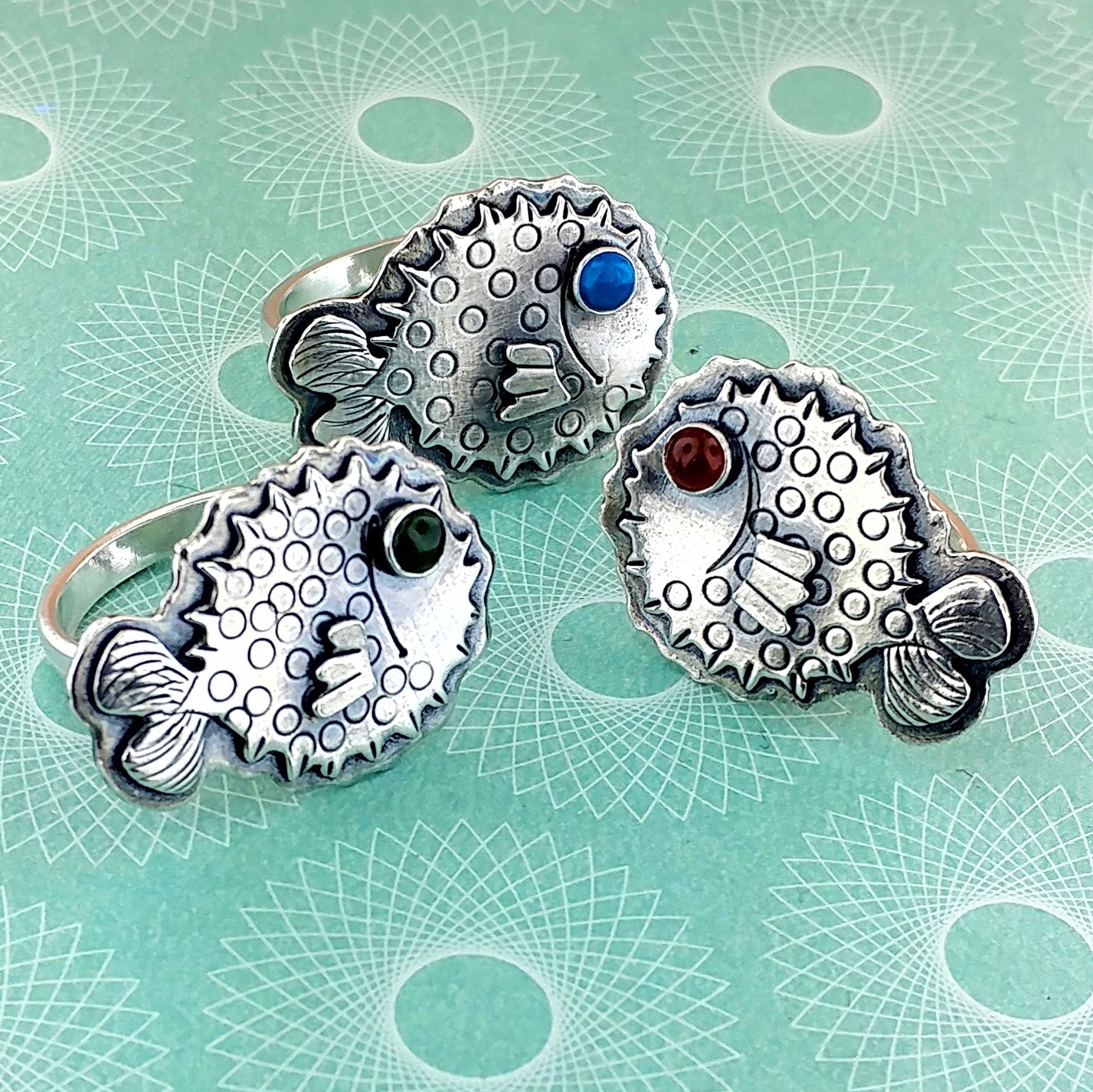 A trio of pufferfish rings with gemstone eyes