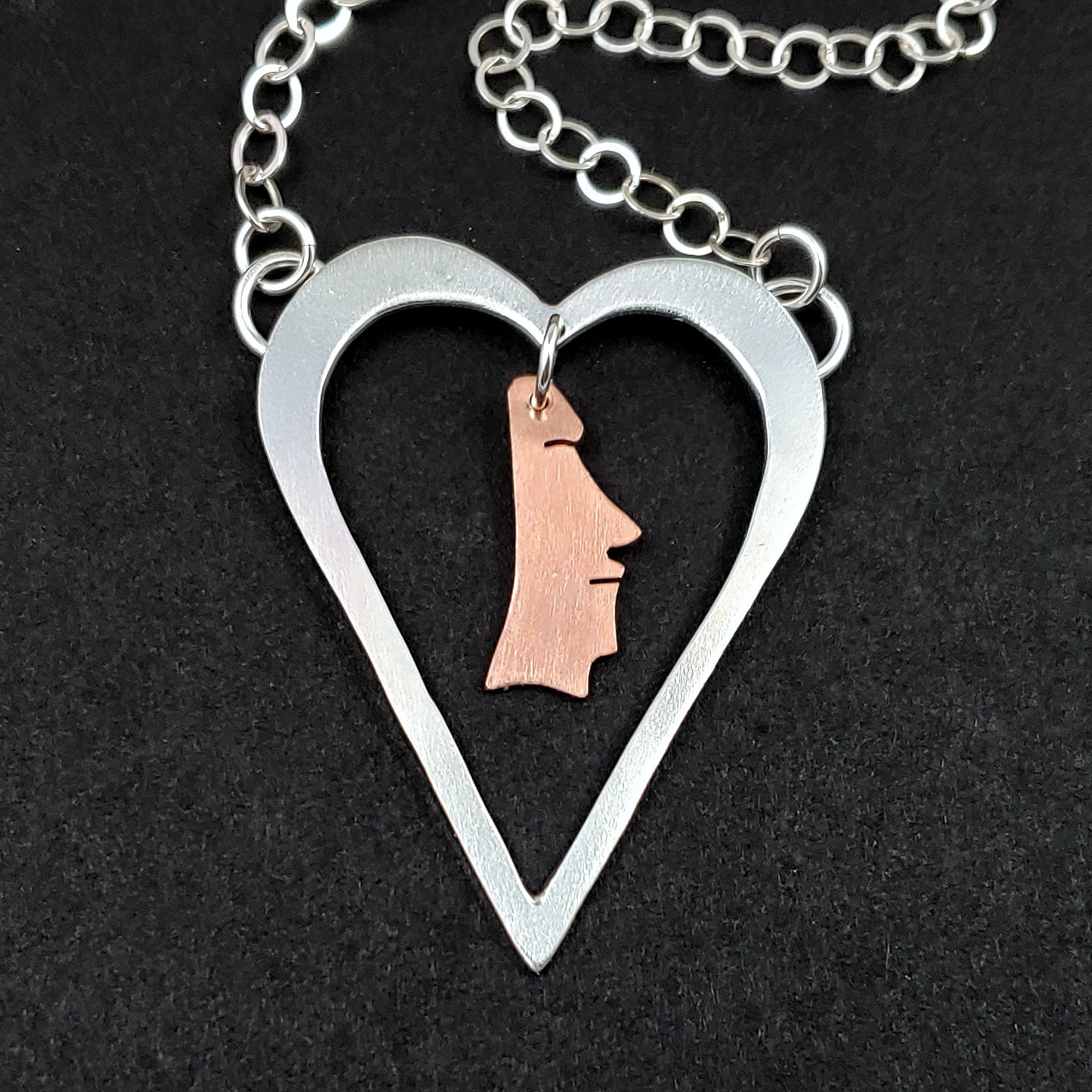 Sterling silver heart necklace with a copper moai head in the middle