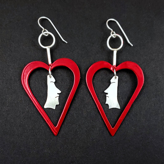 Red powdercoated heart shaped earrings with sterling silver moai heads in the center
