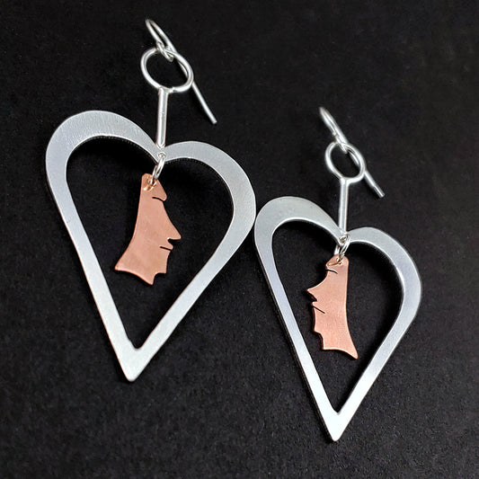 Sterling silver heart shaped earrings with copper moai heads in the middle